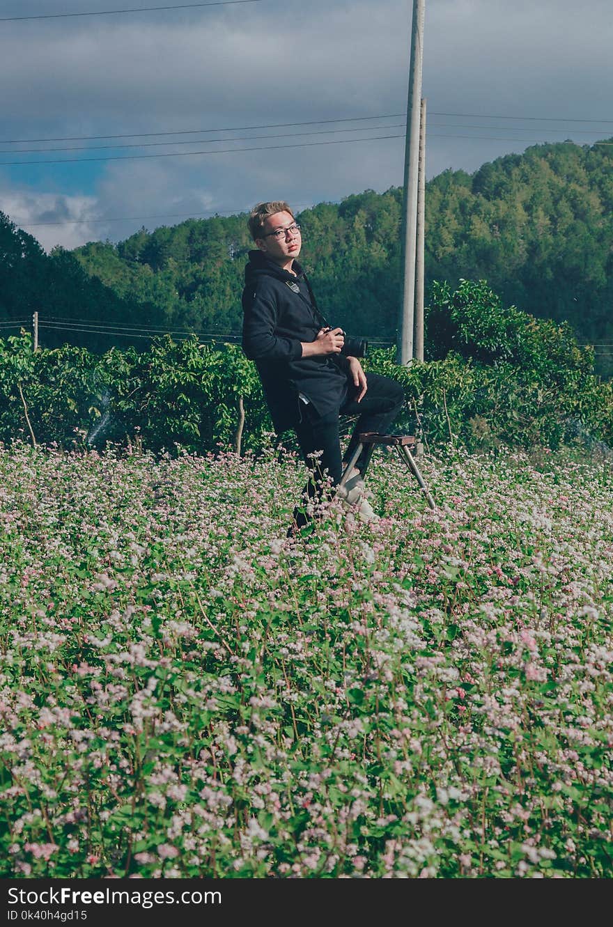 Man Holding Black Dslr Camera on Green Bush at Daytime