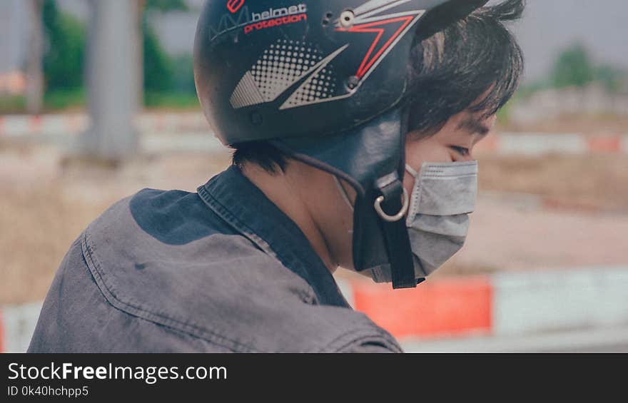 Selective Focus Photography of Person Wearing Black and Red Helmet and Gray Mask