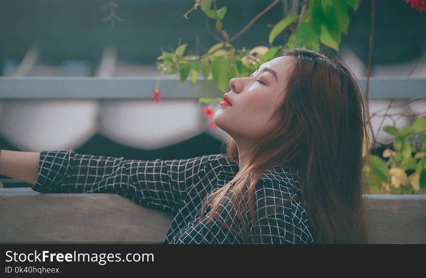 Woman Beside Gray Wall and Green Leaf Plant