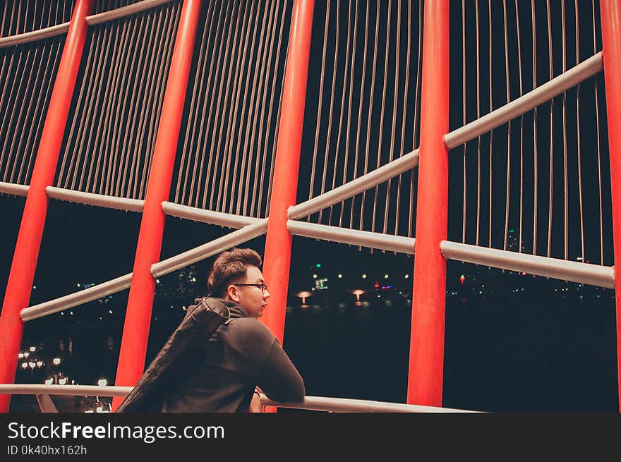 Selective Photography of Man Leaning on White Metal Railings