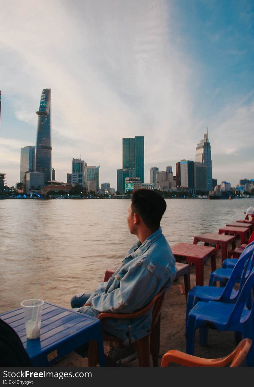 Man Sitting in Front of Body of Water