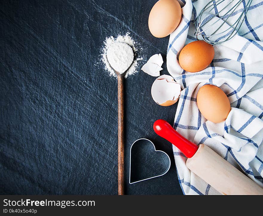 Baking background with eggs and flour on a black stone background. Baking background with eggs and flour on a black stone background