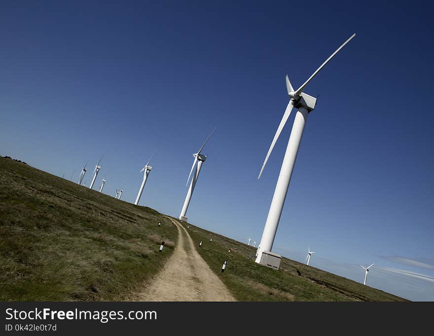 SEVERAL WIND TURBINES ON MOORLAND AGAINST BLUE SKY