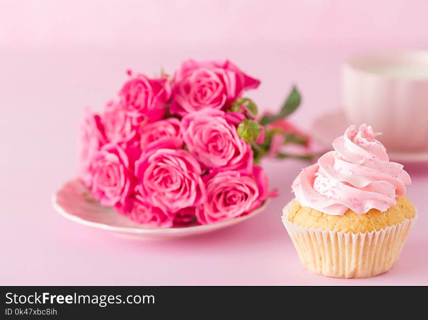 Cupcake with pink cream decoration and roses on pink pastel background - romantic horizontal banner for congratulation, greeting card for birthday, wedding, valentine or women day. Cupcake with pink cream decoration and roses on pink pastel background - romantic horizontal banner for congratulation, greeting card for birthday, wedding, valentine or women day.