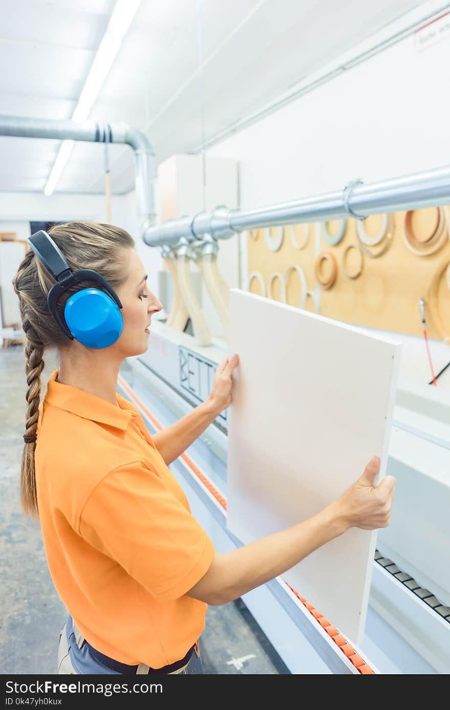 Woman carpenter working in furniture factory working