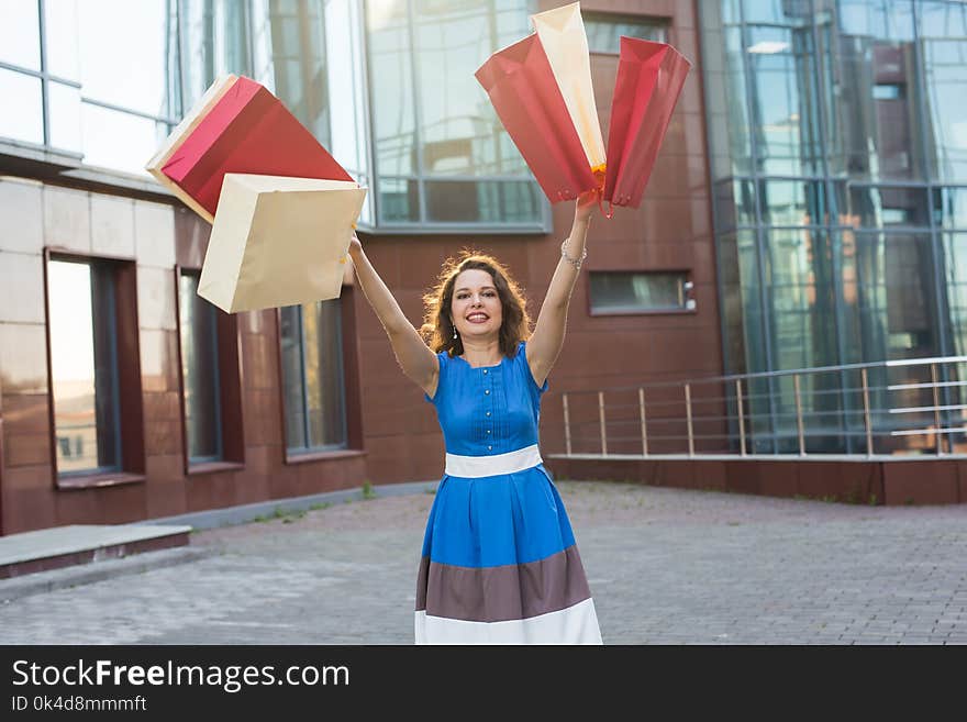 Happiness, consumerism, sale and people concept - woman with shopping bags