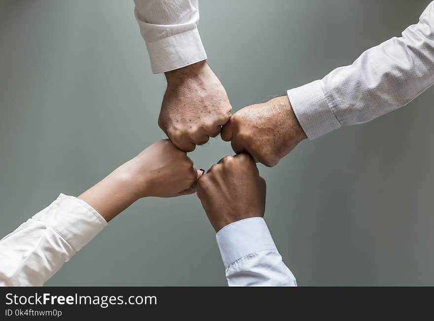 Four Person Hands in White Dress Shirts