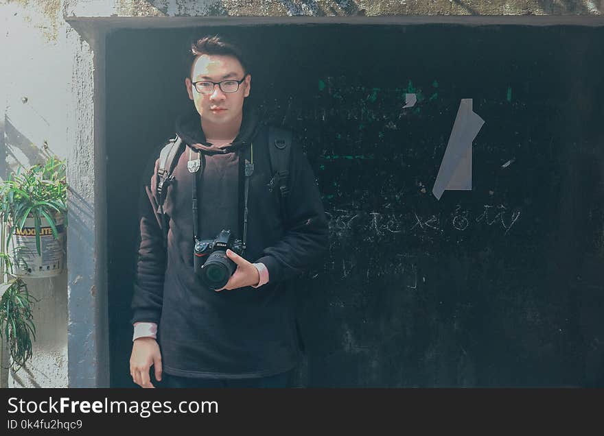 Man in Black Pullover Hoodie Holding Black Dslr Camera