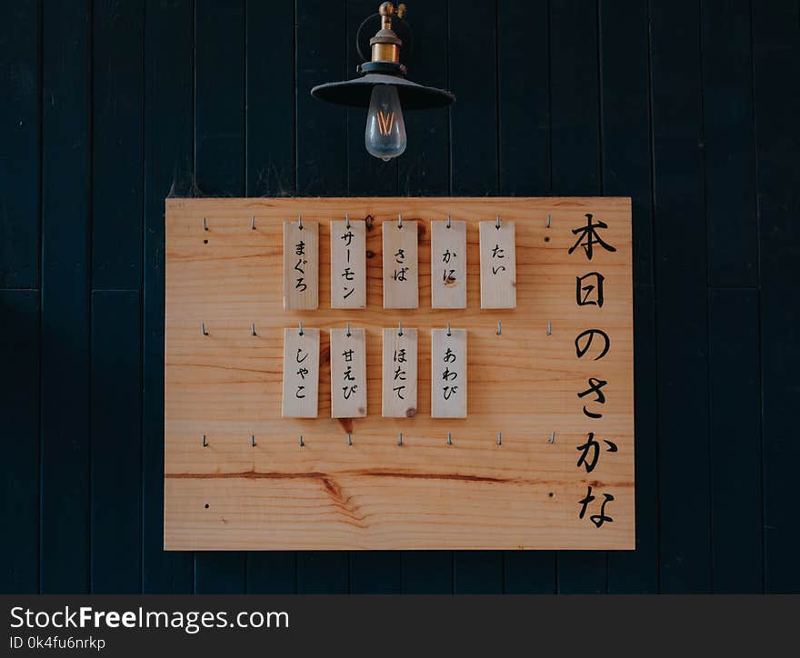 Brown Wooden Signage on Black Wooden Wall