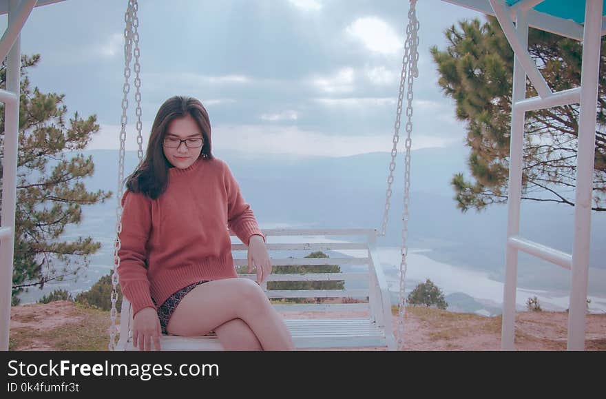 Woman Sitting on White Canopy Swing