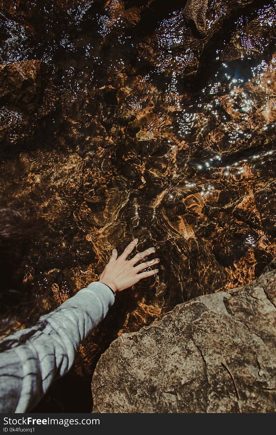 Person Touching Brown Stone