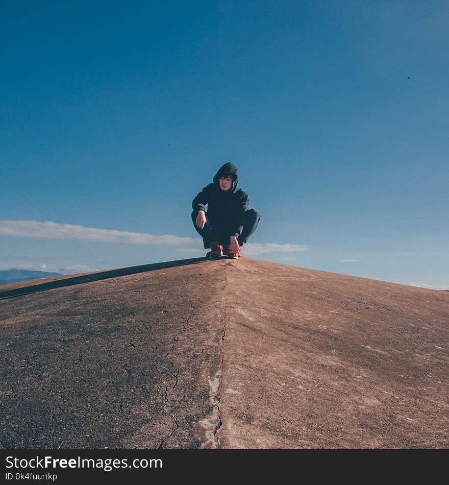 Photo of Man in the Middle of Concrete Cliff