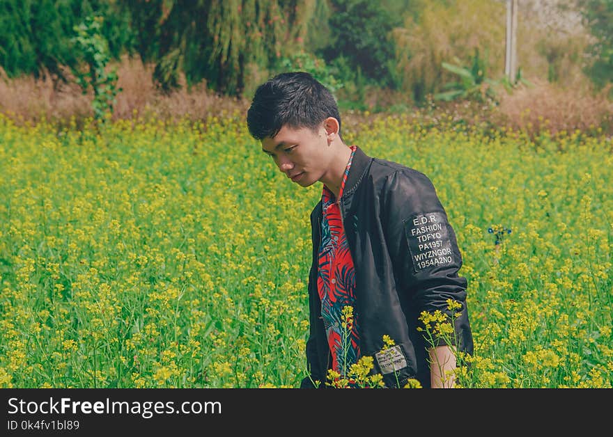 Man Wearing Black Jacket on Yellow Flowers