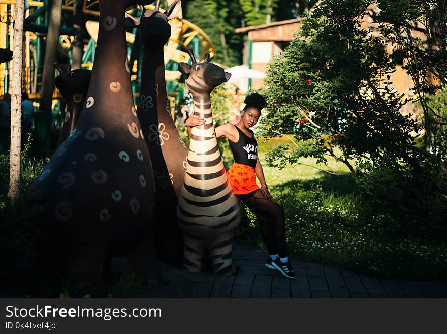 Photo of Woman Sitting on Zebra Statue