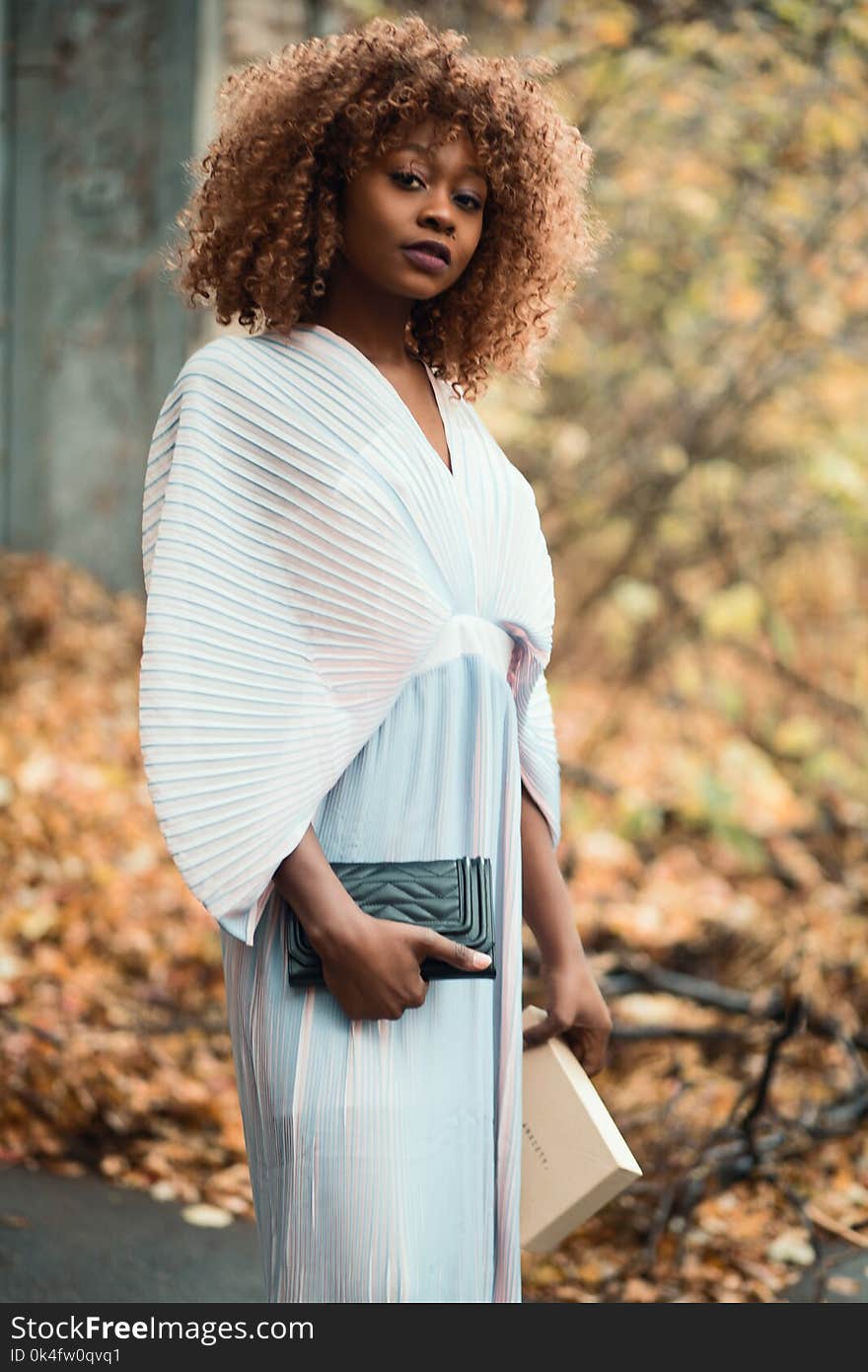 Photo of Woman Wearing White Dress and Holding Black Purse