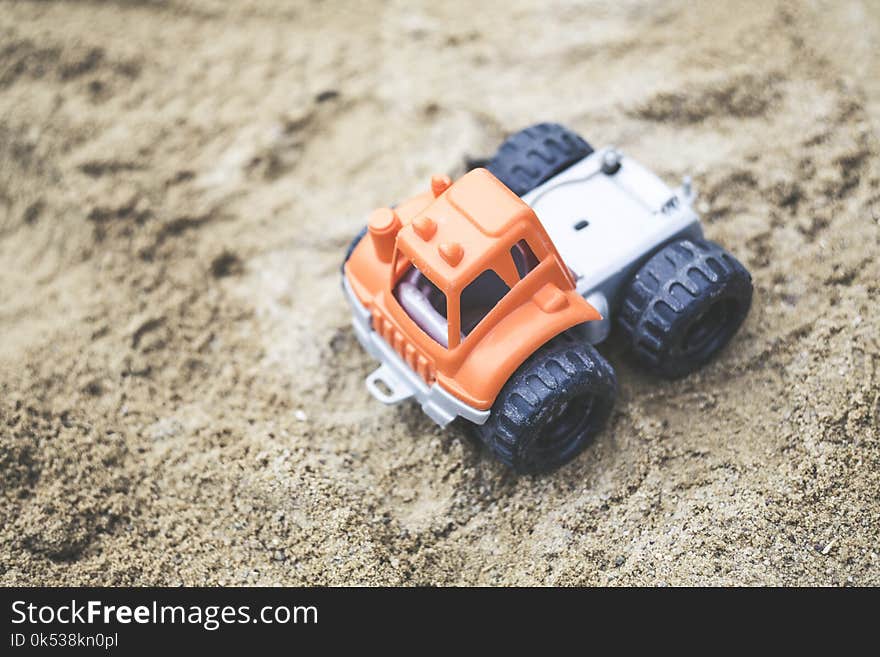 Orange and Gray Plastic Truck Toy on Sand