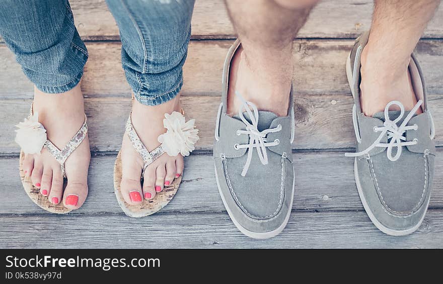 Closeup Photo of Person Wearing Gray Boat Shoes and Gray Flip-flops