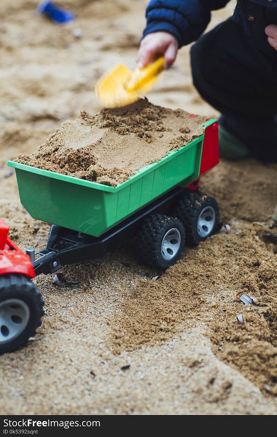 Child Playing Sand With Shovel and Truck Toy