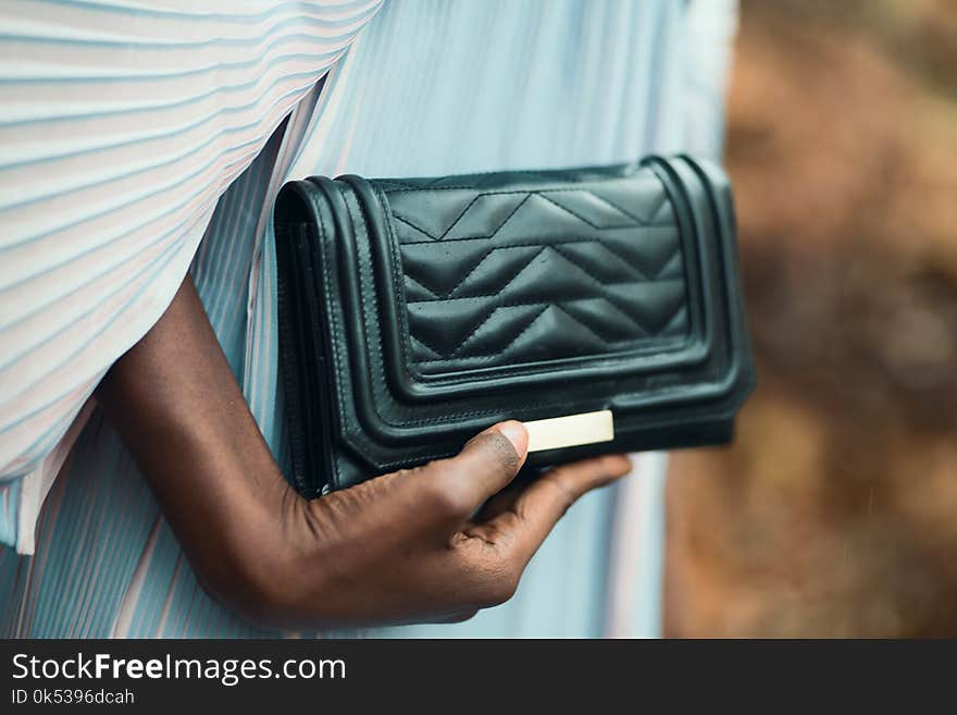 Person Holding Quilted Black Leather Clutch Bag