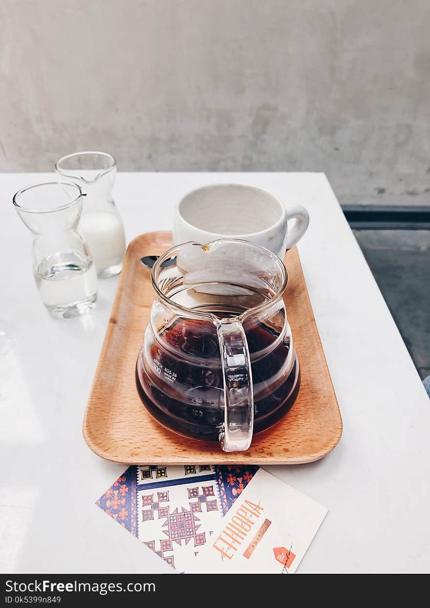 Clear Glass Coffee Pot Near White Mug on Brown Tray