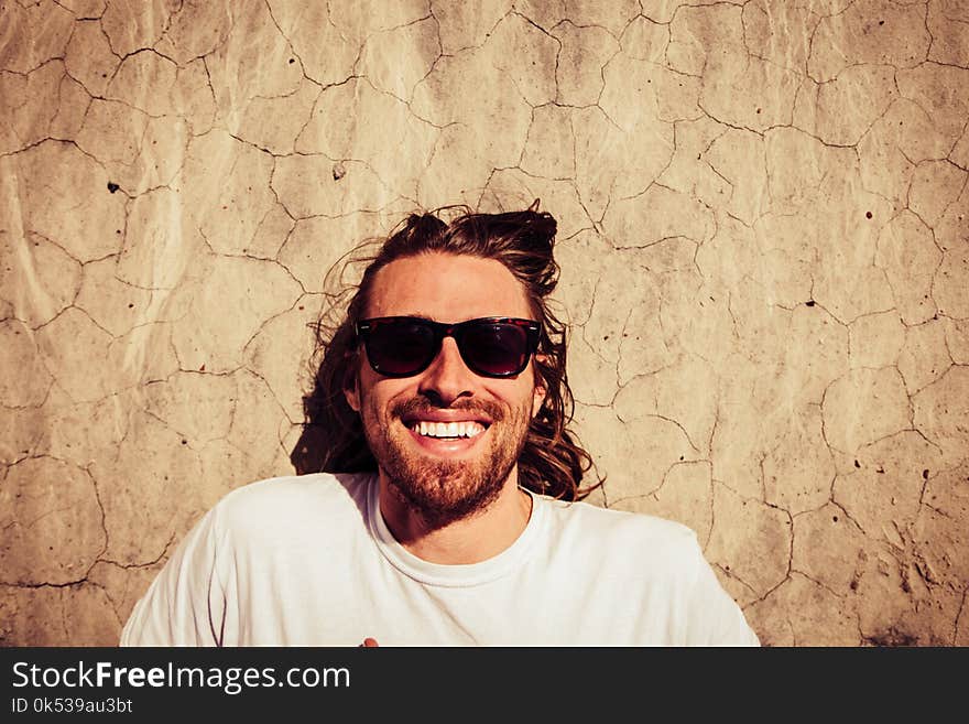 Man Wearing White Crew-neck Shirt Beside Wall