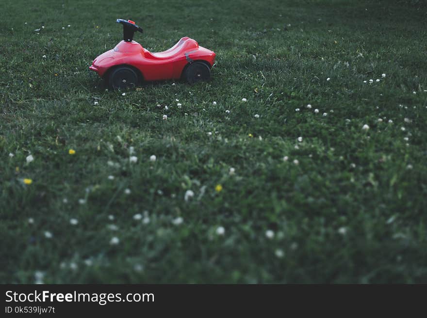 Selective Focus Photography of Red Ride on Toy