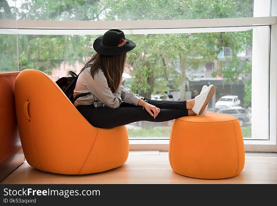 Woman Sitting on Orange Chair