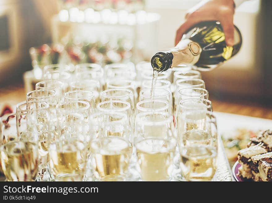 Waiter pouring champagne in stylish glasses at luxury wedding re