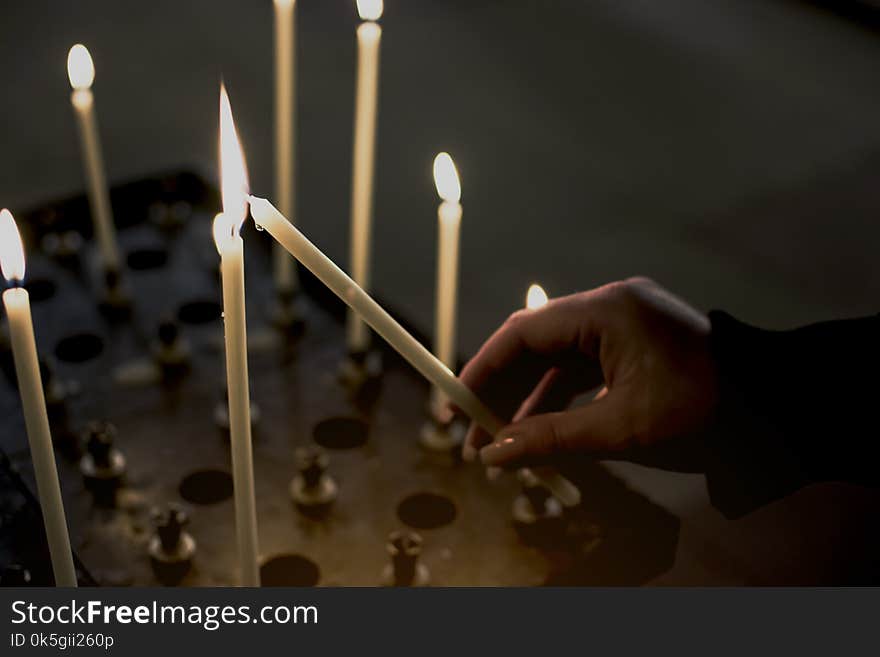 Hand of woman lighting candles in a church, truth religion concept