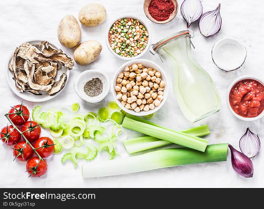 Vegetarian food ingredients for detox lunch. Soup ingredients - chicken broth, celery, leeks, lentils, chickpeas, tomatoes, red onions on a light background, top view. Flat lay