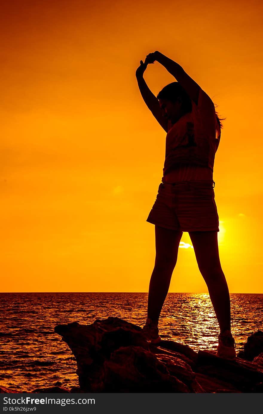 Silhouette woman exercise on the beach sunset.