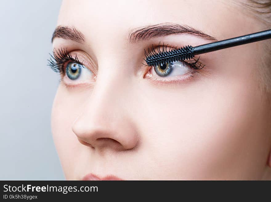 Beautiful woman with long eyelashes in a beauty salon. Eyelash extension procedure. Lashes close-up.