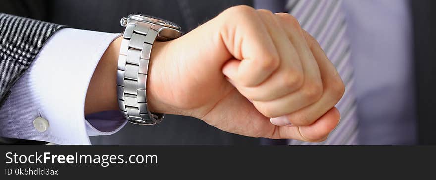 Man in suit and tie check out time at silver wristwatch closeup. Waste minute modern punctual life style start hurry job idea last second clockwork precision concept