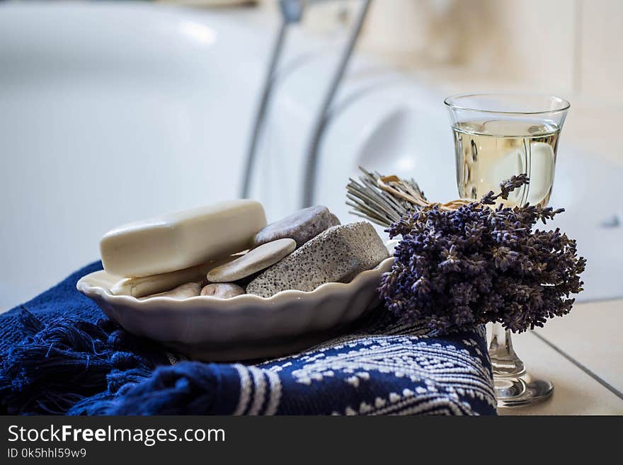 Lavender flowers, towel, bathroom accessories and a glass of white wine - home spa