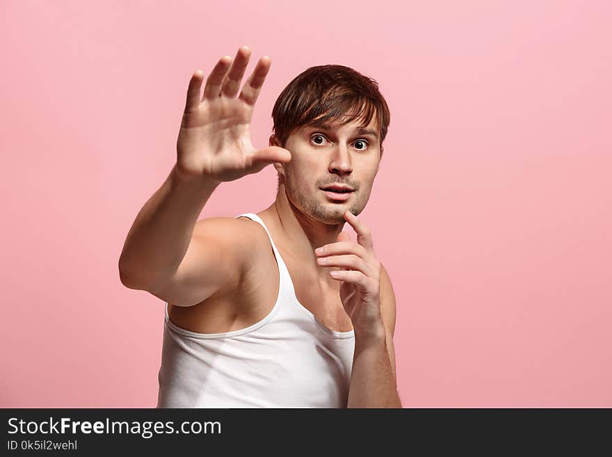 I`m afraid. Fright. Portrait of the scared man.He standing on trendy pink studio background. male half-length portrait. Human emotions, facial expression concept. Front view. I`m afraid. Fright. Portrait of the scared man.He standing on trendy pink studio background. male half-length portrait. Human emotions, facial expression concept. Front view