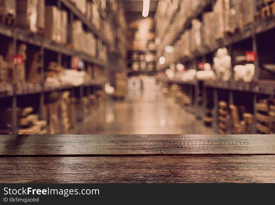 Empty dark wood table top on blurred warehouse background for display your products. Empty dark wood table top on blurred warehouse background for display your products.