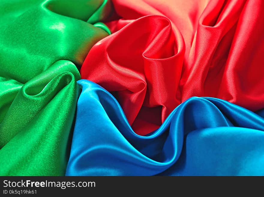 Natural blue, red and green satin fabric as background texture. Natural blue, red and green satin fabric as background texture