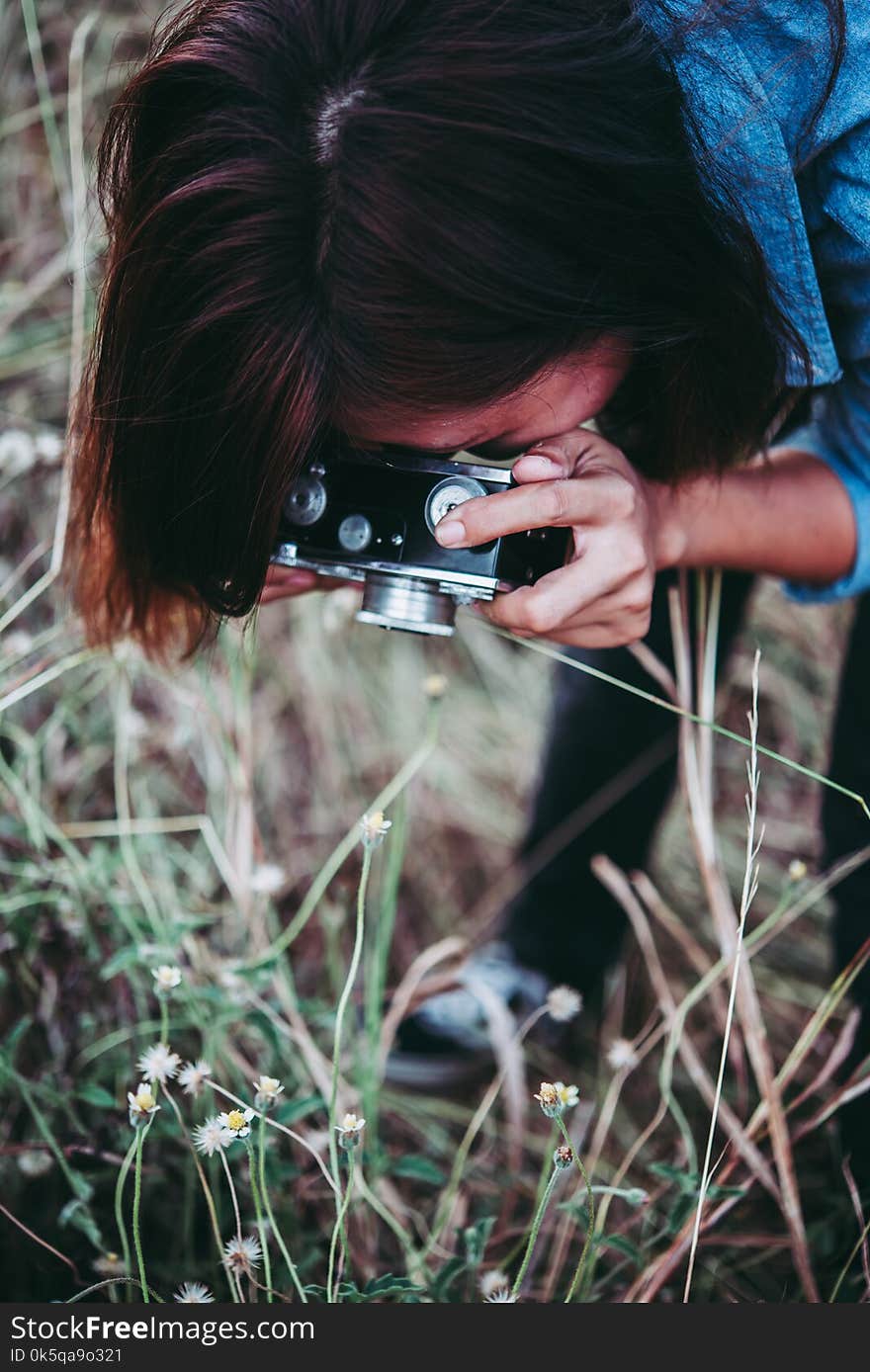 Happy young hipster woman with vintage camera in field. Enjoy with nature sunset, Vintage hipster woman photographer.