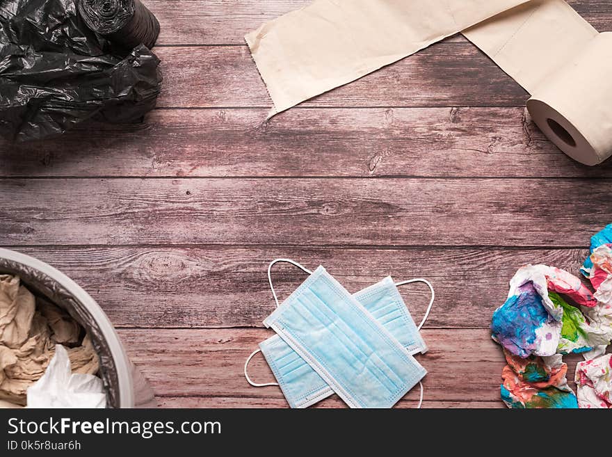 Garbage of dirty paper and sanitary hygiene mask on wooden background composition healthcare concept