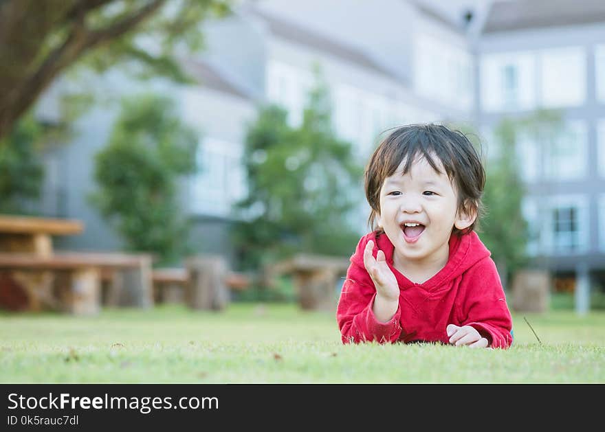 Closeup Happy Asian Kid Lied On Grass Floor In The Garden Background With Cute Motion