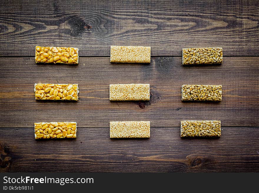 Granola bars for healthy nutritious breakfast on dark wooden background top view pattern