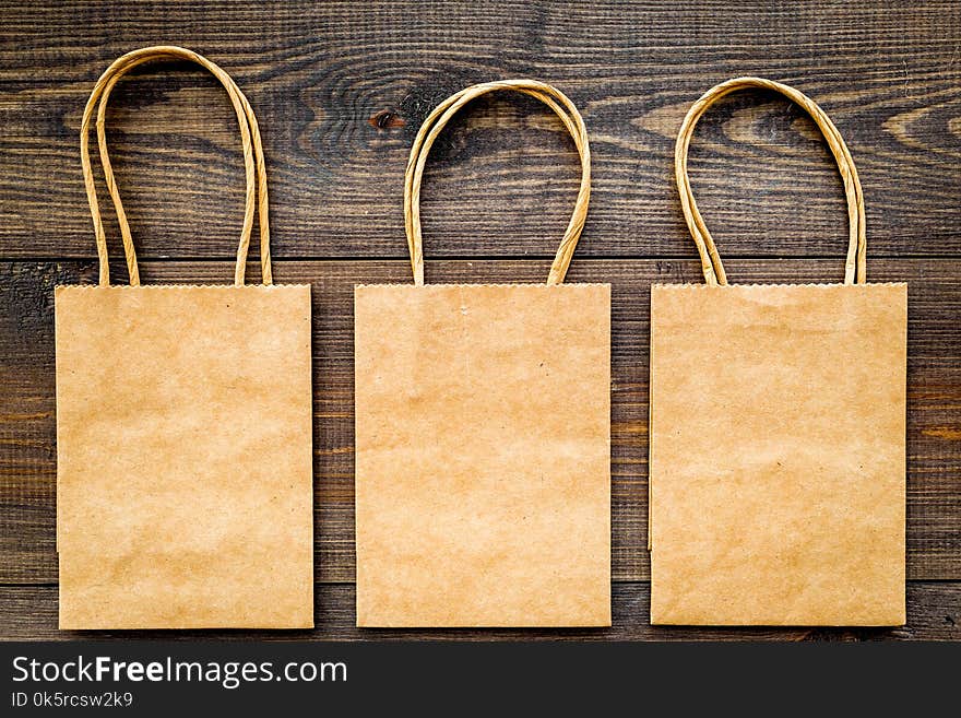 Brown kraft paper bag for shopping on wooden background top view mockup