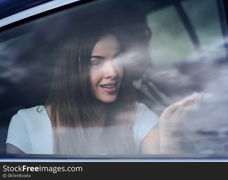 Young Woman Portrait In The Car Behind The Window