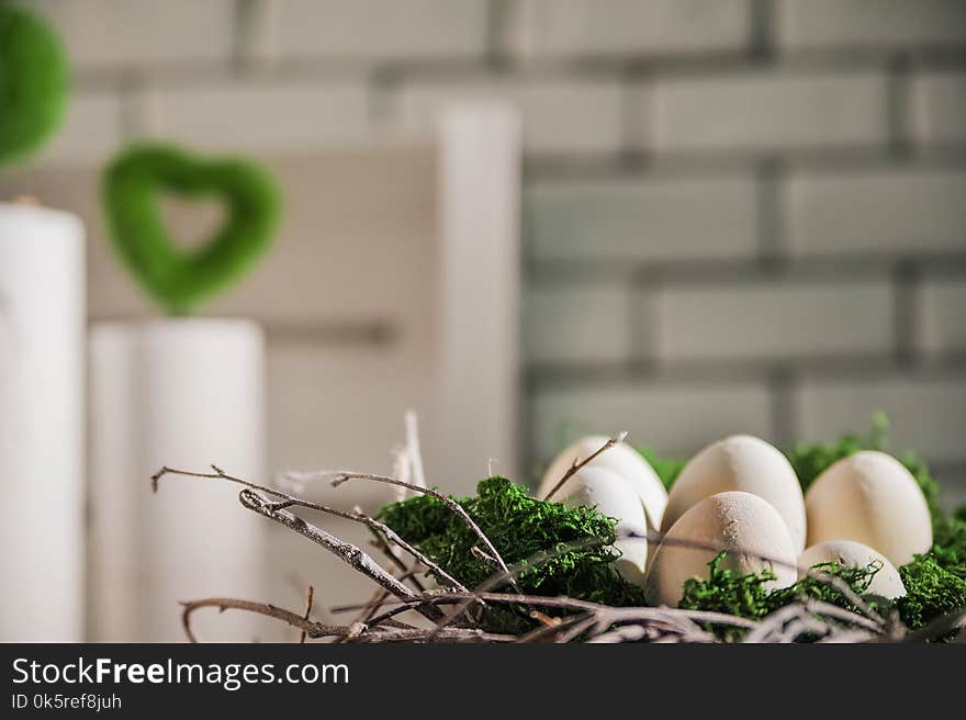 A bright Easter photo with a wreath, concrete vases, concrete eggs, moss. On a white brick wall background for your text