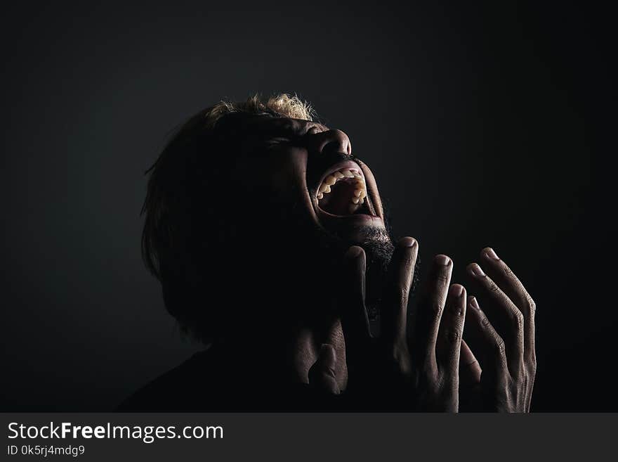 Handsome businessman shouting like crazy, Stressed with work. Studio portrait against black background.