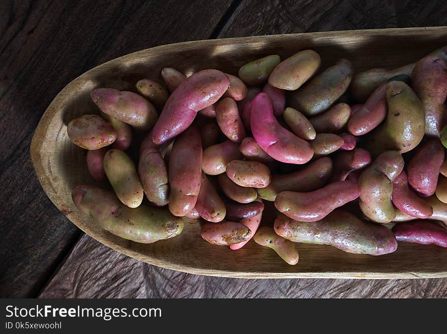 Rustic wooden bowl filled with melloco tuber closeup in Ecuador