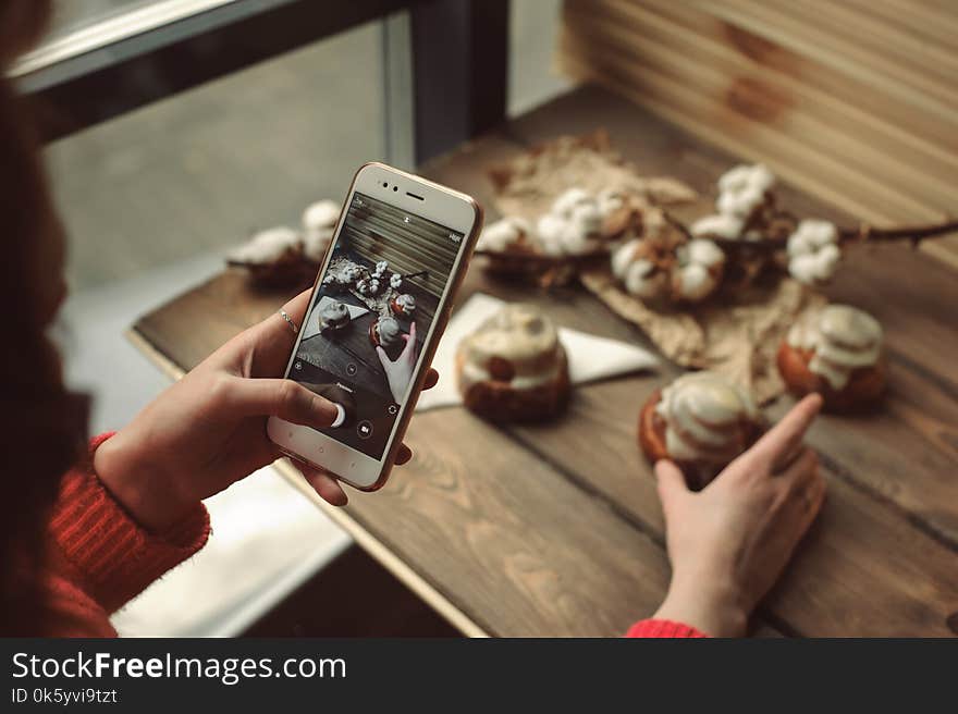 Female Make Mobile Photo With Cinnamon Rolls