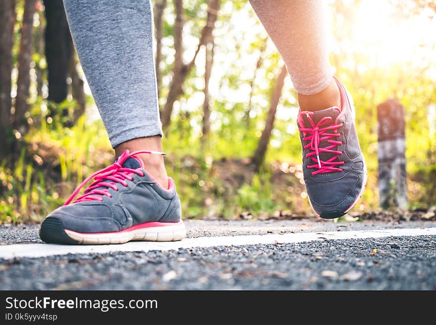 Women runner feet on road in workout wellness.