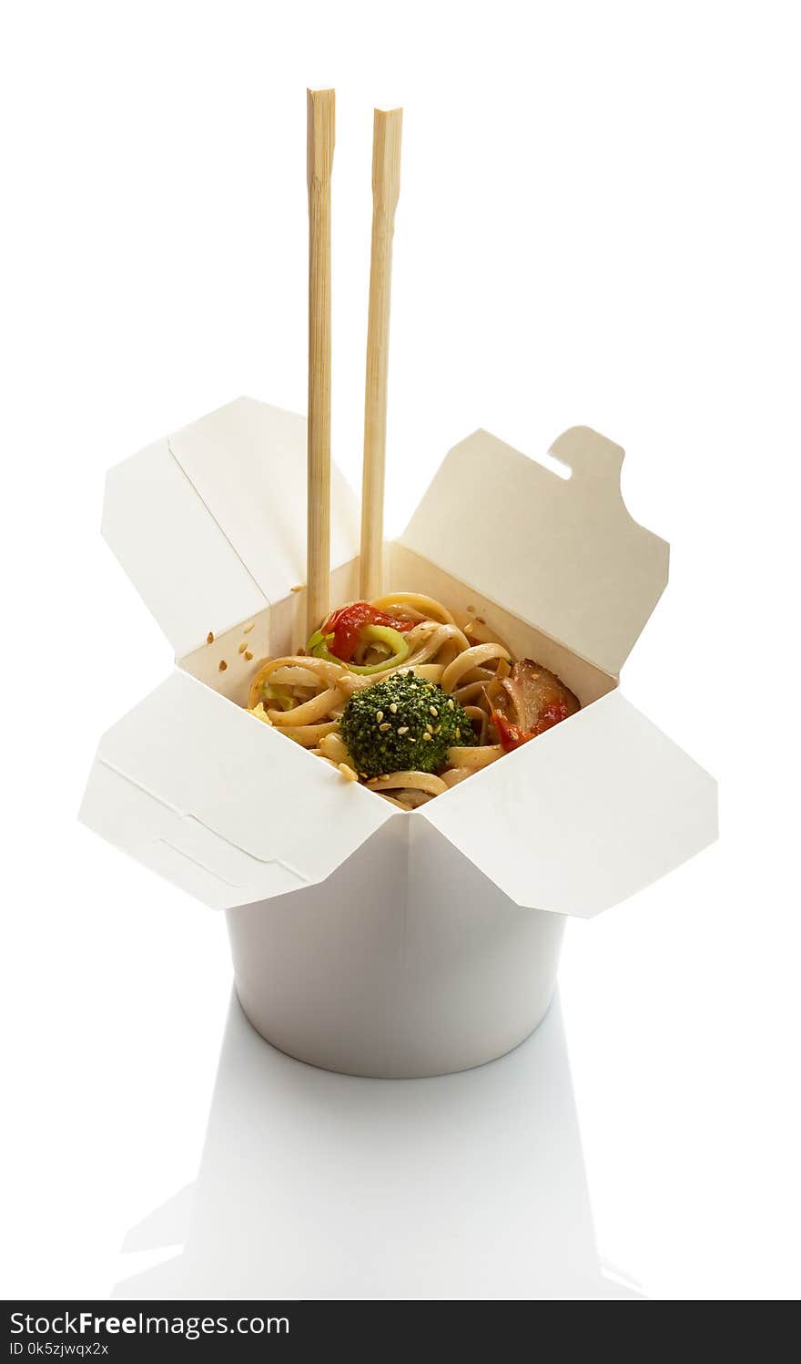 Spicy noodles with meat and vegetables in wok box, chopsticks isolated on white background