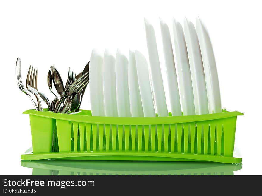 Cutlery and plates on green dryer isolated on white background